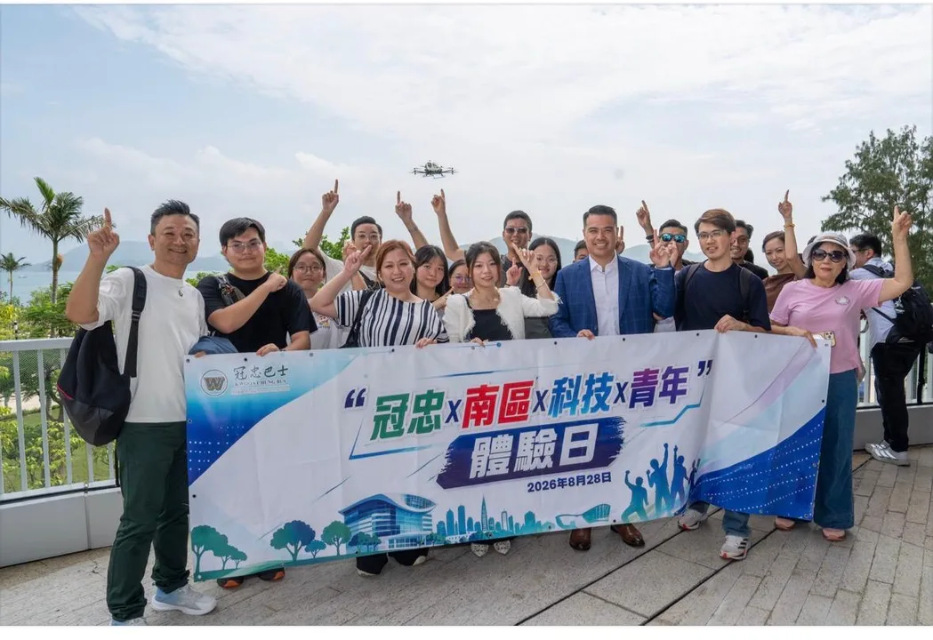 南區青年在數碼港海濱舉起體驗日橫額,EH216-S 在天空飛過